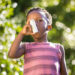 Boy using a asthma inhalator in a park